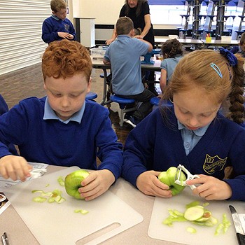 Children pealing apples on the table