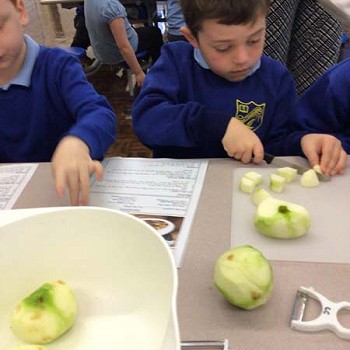 A child cutting apples into cubes
