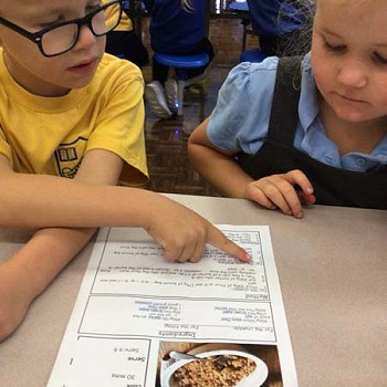 Children reading a recipe on how to make apple crumble