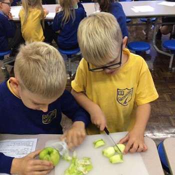 Children cutting and pealing apples on the table