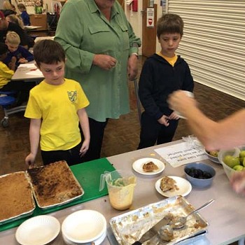 Children selling their apple crumble to members of the community