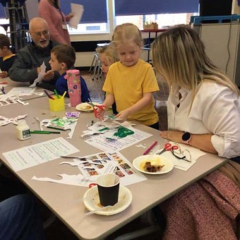 Children sitting next to their family members