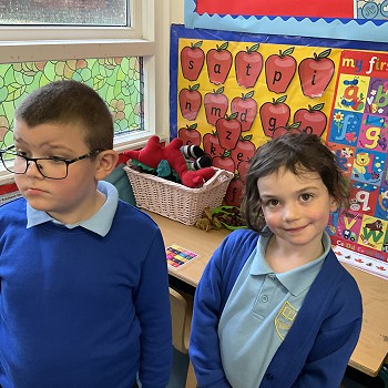 2 students standing next to the alphabet area