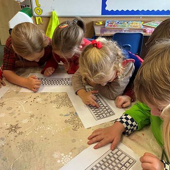 Children looking at a picture of a keyboard to gain experience